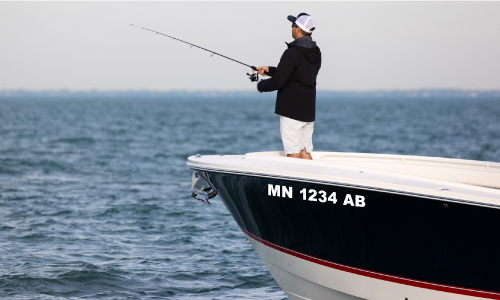 Man fishing on boat with boat registration number decals on the side | Decals.com