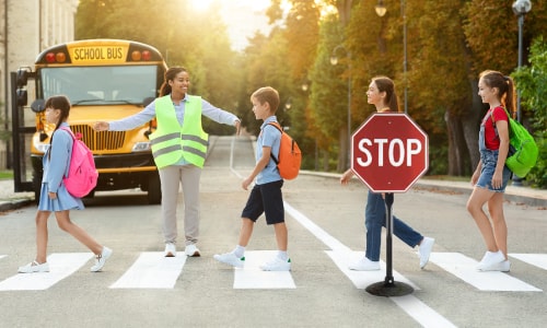 Sign on base at crosswalk with students crossing | Streetsigns.com